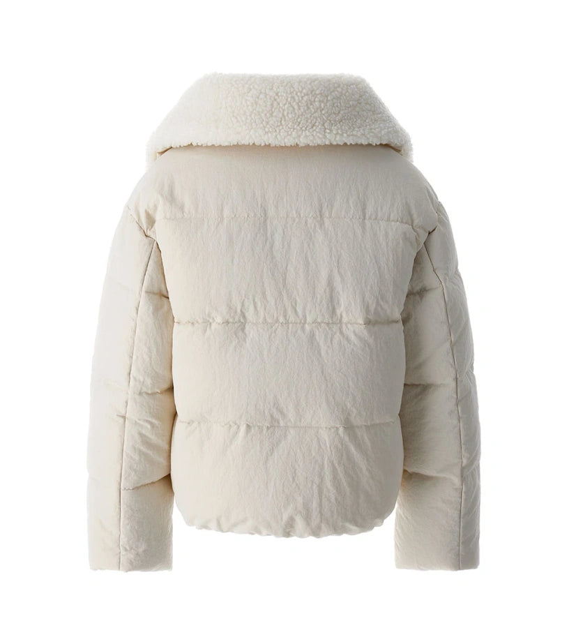 Μπουφάν από καπιτονέ και αφρώδες νάιλον με γιακά από οικολογική γούνα και μακριά μανίκια. Διαθέτει φόδρα από νάιλον, φερμουάρ σε μονόχρωμο τόνο, μπροστινές τσέπες και κεντημένο σήμα για ένα ζεστό, κομψό και μοντέρνο στυλ, ιδανικό για τις κρύες μέρες του χειμώνα.