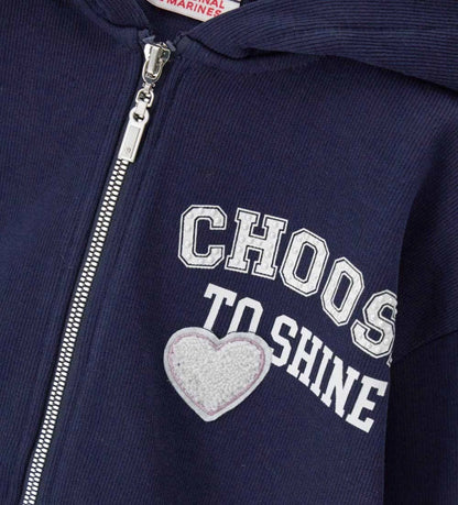 Ζακέτα με κουκούλα σε ριπ ύφανση, με μακριά μανίκια και ριμπ τελειώματα. Διαθέτει κλείσιμο με φερμουάρ, τύπωμα και απλικέ στο μπροστινό μέρος, καθώς και τύπωμα στο πίσω, για μοντέρνα και σπορ εμφάνιση.