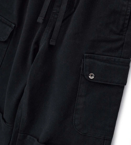 Παιδικό baggy παντελόνι από βαμβακερό twill με κορδόνι και ελαστική μέση και τελείωμα για άνετη εφαρμογή. Διαθέτει μπροστινές τσέπες με ρέλι, πλαϊνές τσέπες και μεταλλικό διακοσμητικό με λογότυπο για μια κομψή πινελιά. Ιδανικό για μοντέρνες και άνετες casual εμφανίσεις.