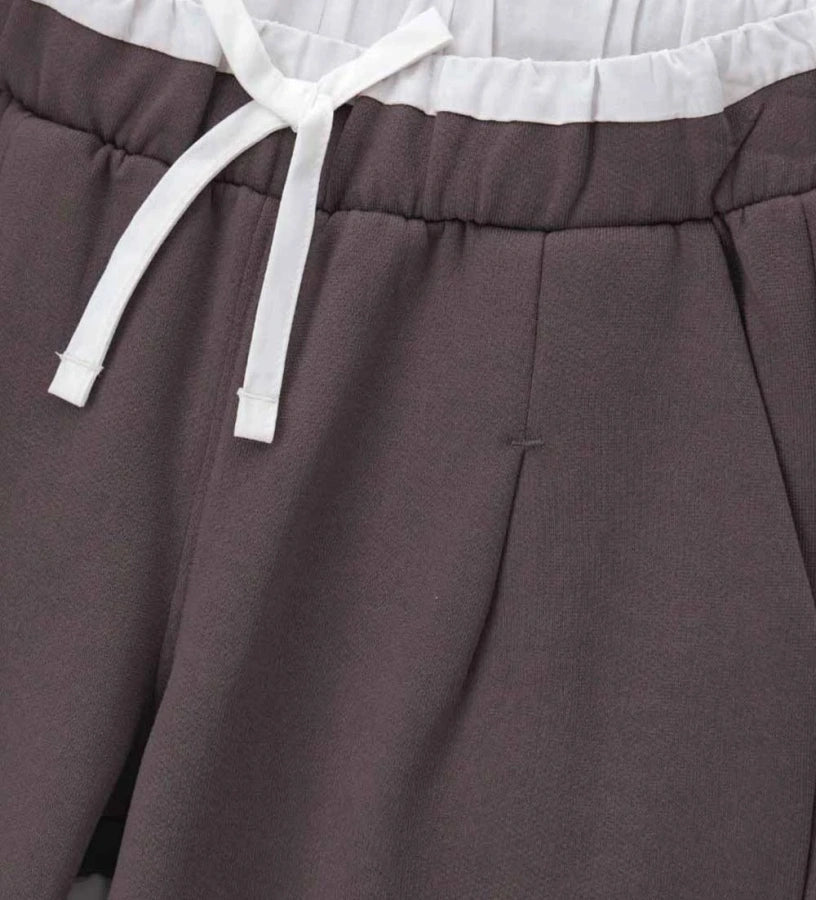 Παντελόνι από βαμβάκι με ελαστική μέση και πιέτες για άνετη και μοντέρνα εφαρμογή. Διαθέτει μπροστινές τσέπες και διακοσμητική λεπτομέρεια σε αντίθεση στο λάστιχο της μέσης, που χαρίζει μοναδικό και κομψό στυλ. Ιδανικό για casual αλλά προσεγμένες παιδικές εμφανίσεις.