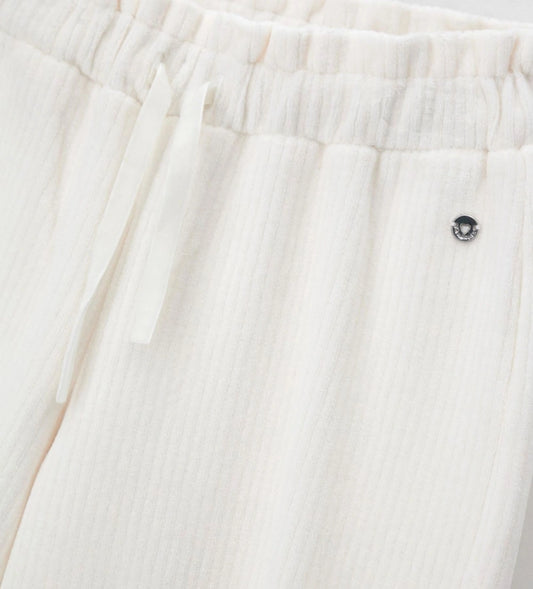 Παντελόνι από βελουτέ ύφασμα (κορδέλα) με ελαστική μέση και κορδόνι για τέλεια εφαρμογή. Διακοσμημένο με μεταλλικά ασημί διακοσμητικά με λογότυπο, αποτελεί ιδανική επιλογή για κάθε περίσταση, συνδυάζοντας άνεση και κομψό στυλ.