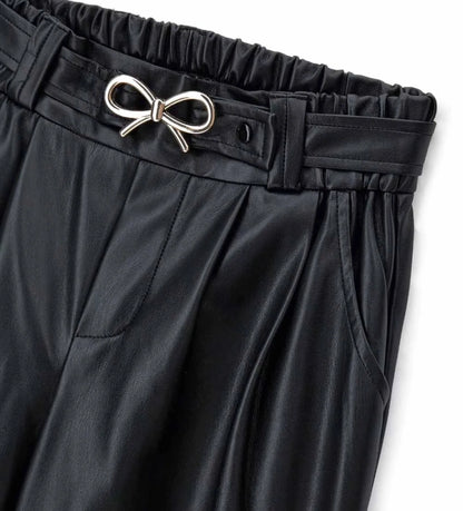 Παντελόνι από οικοδερμάτινη ύλη με ελαστική μέση και μπροστινές τσέπες. Φαρδιά γραμμή στα πόδια και αφαιρούμενη ζώνη με μεταλλική αγκράφα για ένα μοντέρνο, τολμηρό και σούπερ στιλάτο look.