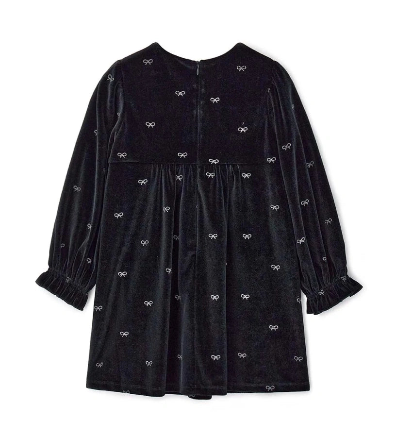 Φόρεμα από βελούδο chenille με allover glitter print, ιδανικό για ένα λαμπερό και μοντέρνο look. Στρογγυλή λαιμόκοψη, άνοιγμα στην πλάτη με αόρατο φερμουάρ και puff μανίκια με σούρες στις μανσέτες.