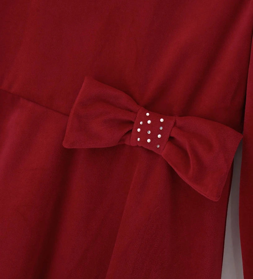 Φόρεμα από βελούδο με στρογγυλή λαιμόκοψη και κλείσιμο στο πίσω μέρος με αόρατο φερμουάρ. Μακριά μανίκια και βαμβακερή φόδρα, διακοσμημένο με φιόγκο στη μέση για ένα κομψό και εκλεπτυσμένο look.