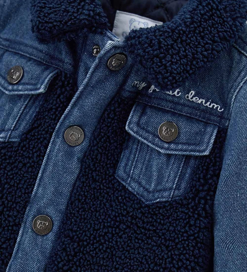 Βρεφικό μπουφάν από τζιν και ύφασμα τύπου teddy, ελαφρώς καπιτονέ και επενδυμένο για άνεση και ζεστασιά. Διαθέτει πρακτικό άνοιγμα με κουμπιά-σούστες και διακοσμητικό κέντημα στο μπροστινό μέρος, για ένα κομψό και πρακτικό look ιδανικό για καθημερινή χρήση.