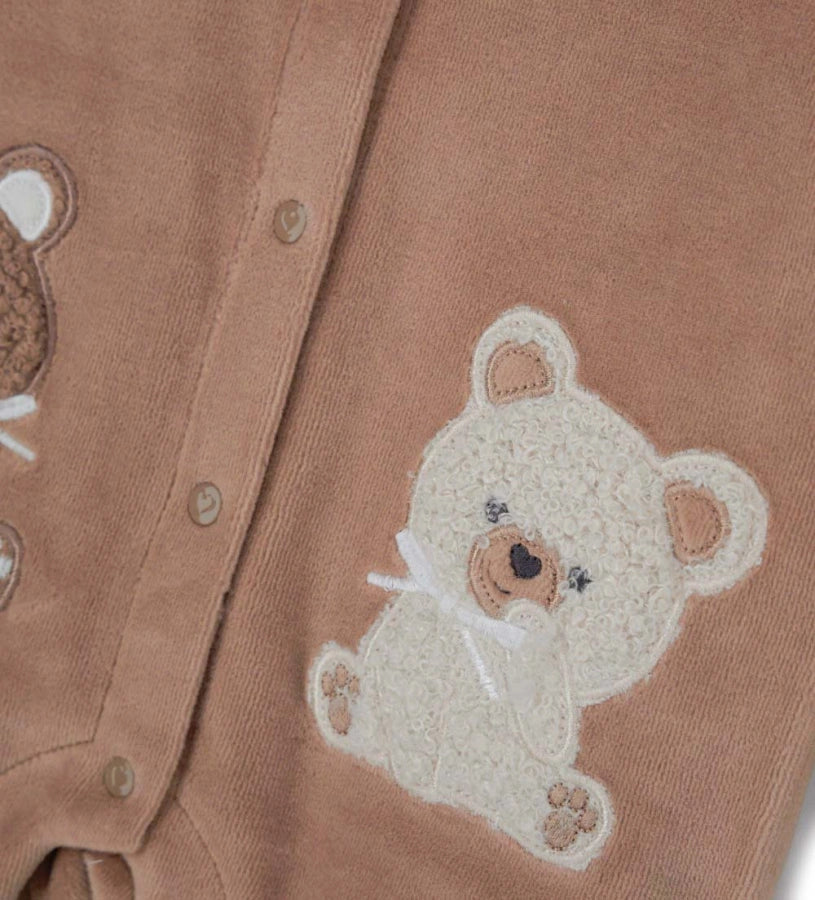 Ολόσωμη φόρμα από βελούδινο chenille με μακριά μανίκια και στρογγυλό γιακά με ρέλι στο τελείωμα. Διαθέτει κέντημα και πρακτικό μπροστινό άνοιγμα με κουμπιά-σούστες. Κεντημένες και απλικέ λεπτομέρειες στο μπροστινό μέρος, ιδανική για τις πιο κρύες μέρες.