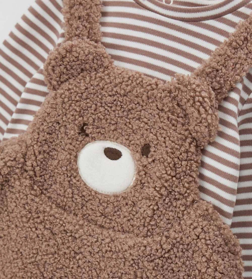 Δίχρωμο σετ δύο τεμαχίων με βαμβακερό κορμάκι μακρυμάνικο σε νήμα βαφής, στρογγυλή λαιμόκοψη, πρακτικά κουμπιά-σούστες στο πίσω μέρος και στο κάτω μέρος, καθώς και κέντημα. Ολόσωμο ρούχο από οικολογική γούνα, με απαλή jersey επένδυση, ρυθμιζόμενες τιράντες, κέντημα και απλικέ λεπτομέρειες.