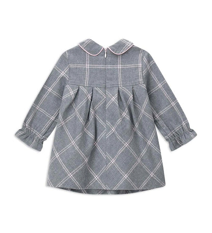 Φόρεμα από καρό ύφασμα με γιακά πουκαμίσου και μακριά μανίκια με σούρα στον καρπό. Το μπροστινό κέντημα προσθέτει μια κομψή και εκλεπτυσμένη πινελιά, ενώ το κρυφό φερμουάρ στο πίσω μέρος εξασφαλίζει πρακτικό και διακριτικό κλείσιμο. Ιδανικό για κοριτσίστικες εμφανίσεις με στυλ και φινέτσα.