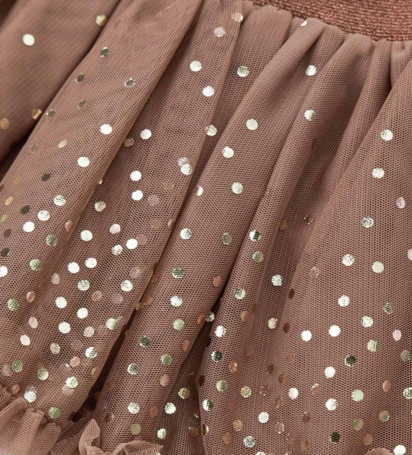 Φούστα από τούλι με ελαστική μέση για άνετη και πρακτική εφαρμογή. Διακοσμημένη με κομψό βολάν στο κάτω μέρος και μεταλλικό τύπωμα μπροστά και πίσω, για μια λαμπερή και μοντέρνα πινελιά.