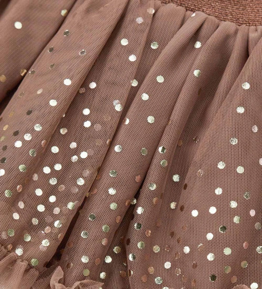 Φούστα από τούλι με ελαστική μέση για άνετη και πρακτική εφαρμογή. Διακοσμημένη με κομψό βολάν στο κάτω μέρος και μεταλλικό τύπωμα μπροστά και πίσω, για μια λαμπερή και μοντέρνα πινελιά.