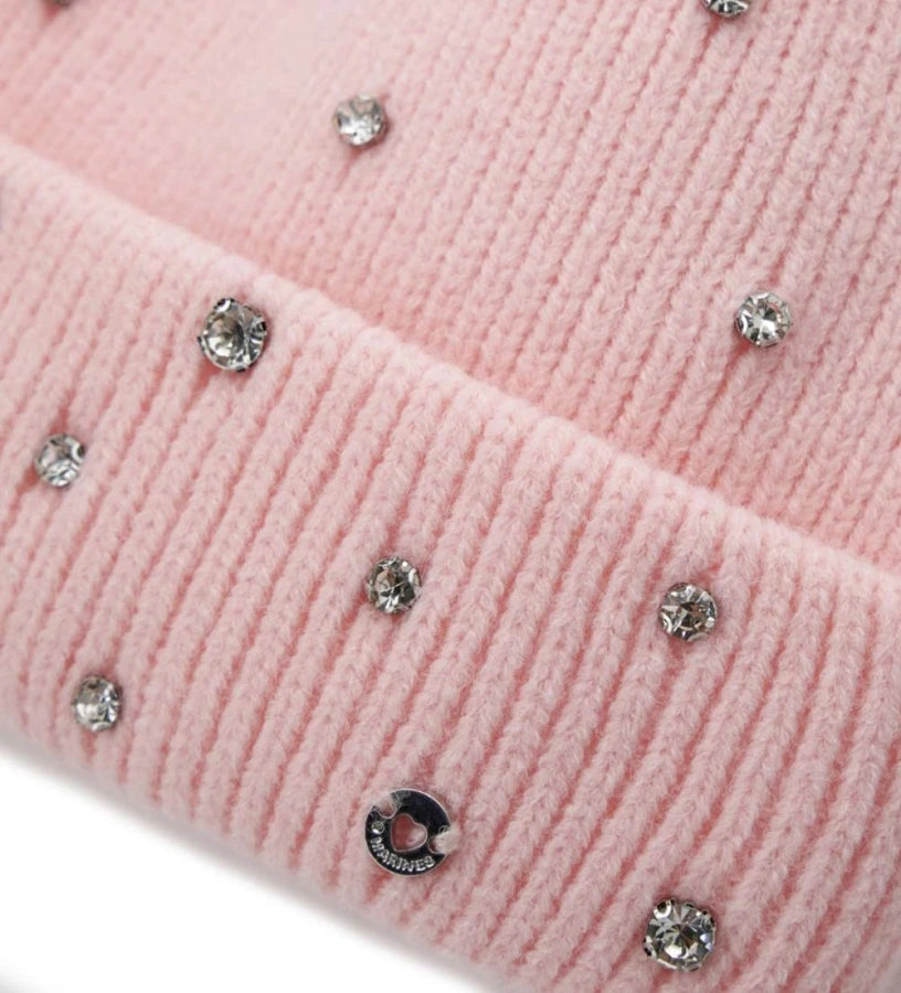 Πλεκτό σκουφάκι με ρεβέρ, διακοσμημένο με στρας για λαμπερή εμφάνιση. Ένα αξεσουάρ που συνδυάζει άνεση και στυλ, ιδανικό για να προσθέσει μια πινελιά φωτός και κομψότητας στις χειμερινές εμφανίσεις.