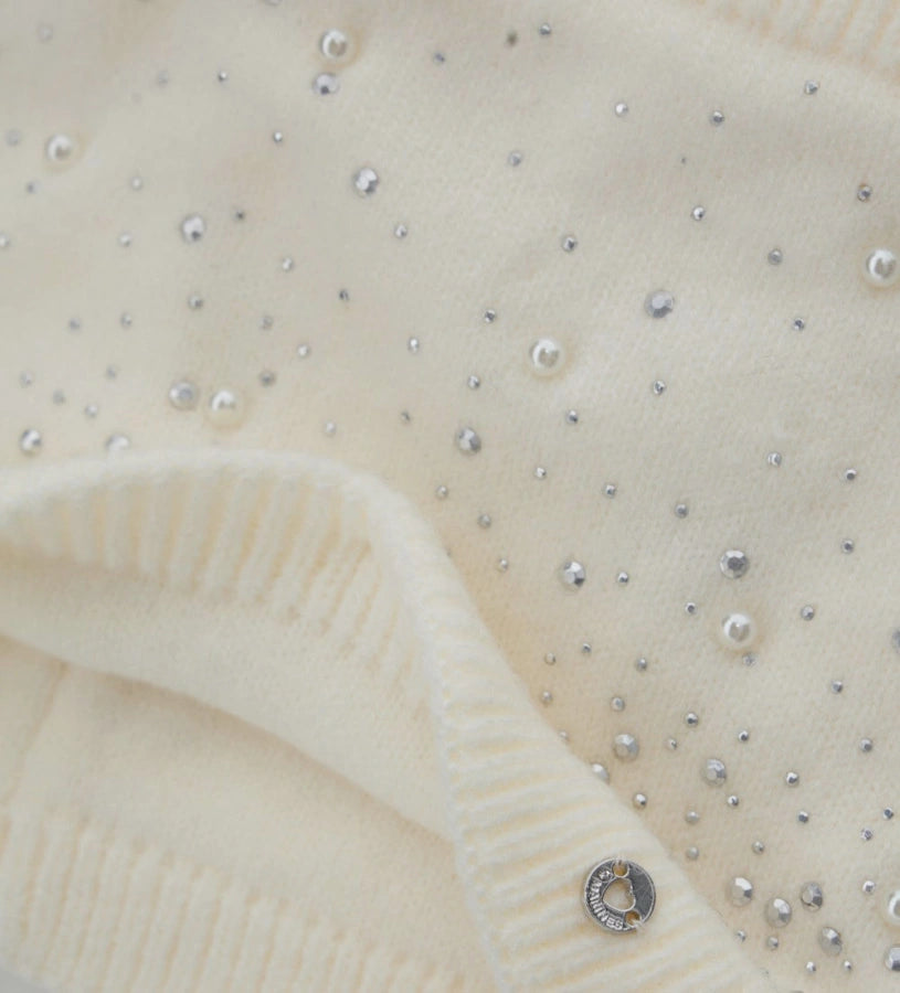 Πλεκτός λαιμός με διακοσμητικά στρας, τρουκς και πέρλες. Ένα ζεστό και εκλεπτυσμένο αξεσουάρ, ιδανικό για να χαρίσει κομψότητα και λάμψη στις χειμερινές εμφανίσεις.