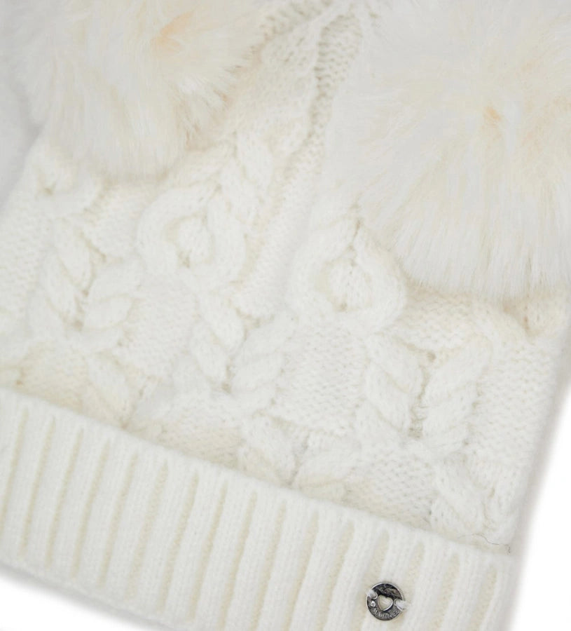 Πλεκτό σκουφάκι με ρεβέρ και δύο φουντάκια, ιδανικό για να προσθέσει μια χαρούμενη πινελιά στις χειμερινές εμφανίσεις.