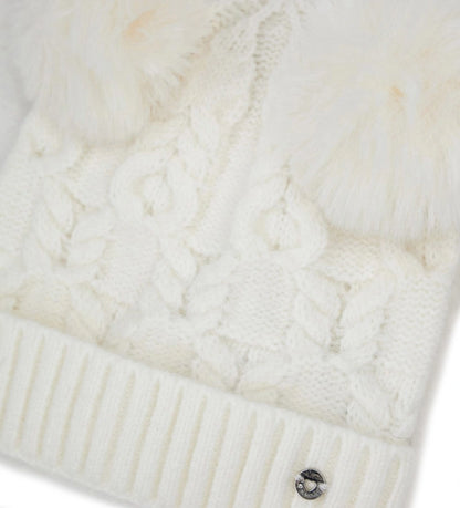 Πλεκτό σκουφάκι με ρεβέρ και δύο φουντάκια, ιδανικό για να προσθέσει μια χαρούμενη πινελιά στις χειμερινές εμφανίσεις.