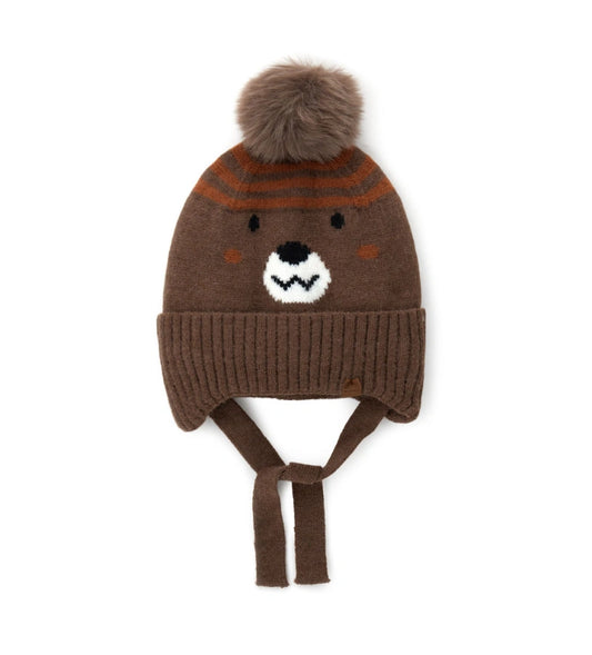 Σκουφάκι με καλύμματα για τα αυτιά, κορδόνια, jacquard σχέδιο ρύγχους και φουντάκι — διασκεδαστικό και πρακτικό για τις κρύες μέρες.