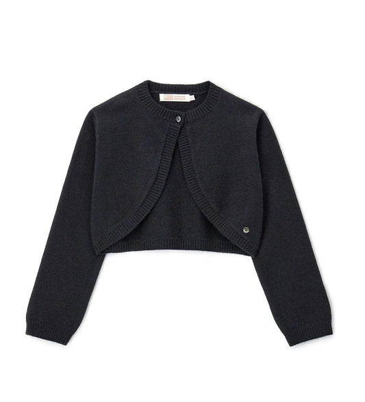 Πλεκτό μπολερό από μείγμα μαλλιού με στρογγυλή λαιμόκοψη, άνοιγμα με κουμπί και ριμπ τελειώματα σε λαιμό και μανσέτες. Ένα κομψό και εκλεπτυσμένο ρούχο, διακοσμημένο με μεταλλικό μενταγιόν.