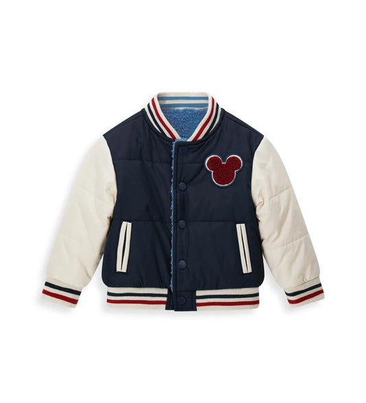 Αναστρέψιμο μπουφάν bomber Disney Mickey Mouse με γέμισμα. Η μία πλευρά από νάιλον με μανίκια σε αντίθεση και μπροστινό απλικέ, και η δεύτερη πλευρά από ζεστό οικολογικό teddy με μανίκια σε αντίθεση και απλικέ. Κλείσιμο με κουμπιά-σούστες και ριμπ τελειώματα από βαμμένο νήμα για ένα δυναμικό και ζεστό στυλ.