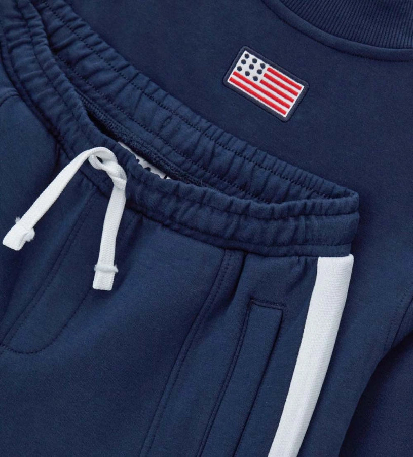 Σετ φόρμας Fila από τεχνικό ύφασμα, με μπλούζα μακρυμάνικη που διαθέτει κρυφό φερμουάρ, τύπωμα στο μπροστινό μέρος και ριμπ τελειώματα, και παντελόνι με ρυθμιζόμενο κορδόνι στη μέση, τυπωμένο λογότυπο και κεντημένη ετικέτα στο πλάι.