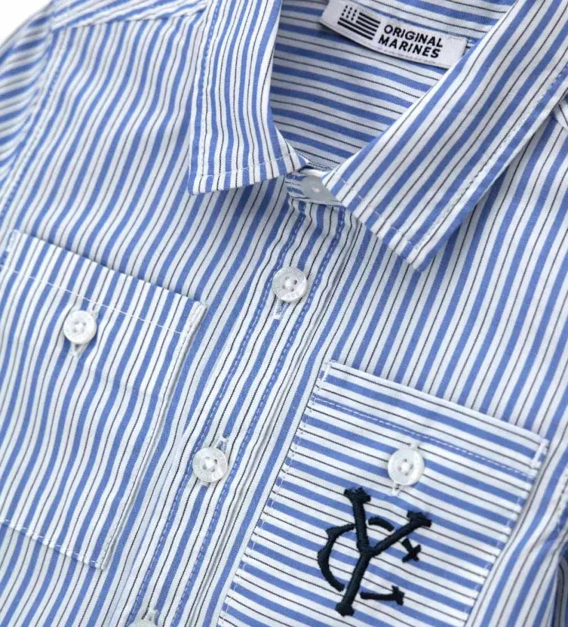 Κοντινό πλάνο στην μπροστινή τσέπη με το διακριτικό κέντημα και το ριγέ μοτίβο του πουκαμίσου.