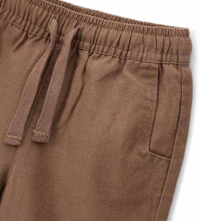 Λεπτομέρεια από το ρυθμιζόμενο κορδόνι και τις μπροστινές τσέπες του αγορίστικου παντελονιού.