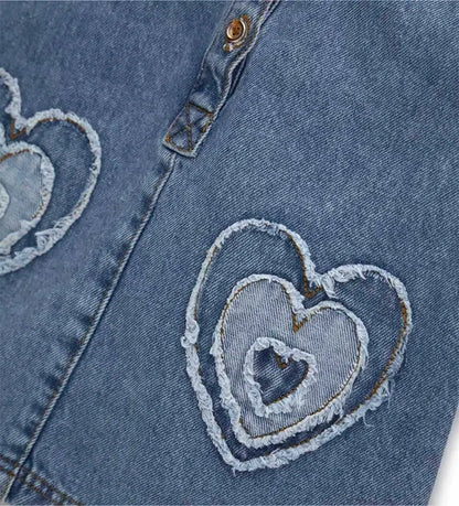 Λεπτομέρεια από τα κουμπιά σούστες και τα "patch" απλικέ στη denim σαλοπέτα.