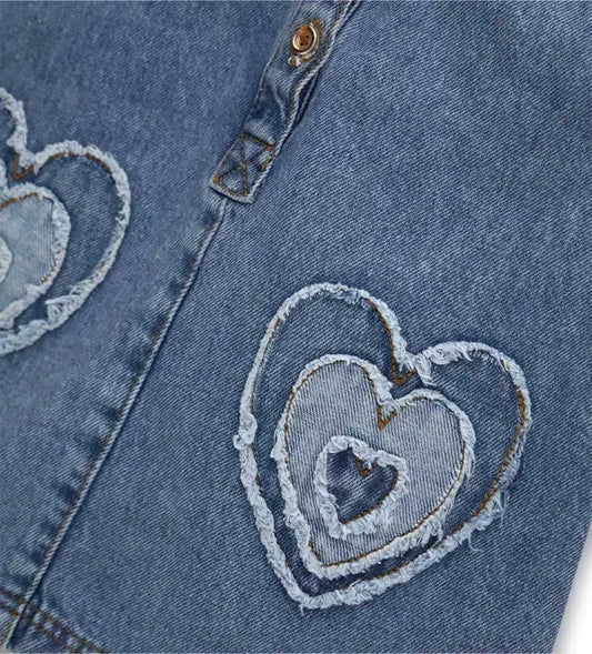 Λεπτομέρεια από τα κουμπιά σούστες και τα "patch" απλικέ στη denim σαλοπέτα.