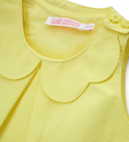 Λεπτομέρεια από το charm στο μπροστινό μέρος και το άνοιγμα στους ώμους της κοριτσίστικης μπλούζας.