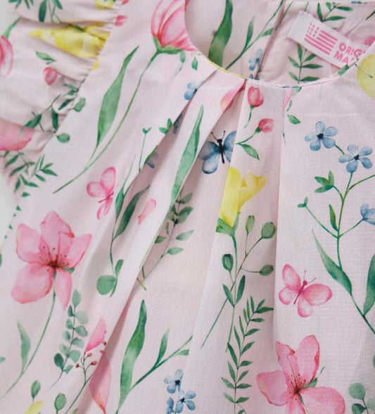 Λεπτομέρεια από τα κουμπιά στην πλάτη και το φλοράλ τύπωμα της παιδικής μπλούζας.