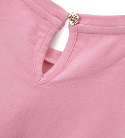 Λεπτομέρεια από τα στρασάκια και το άνοιγμα keyhole στην πλάτη του παιδικού T-shirt.