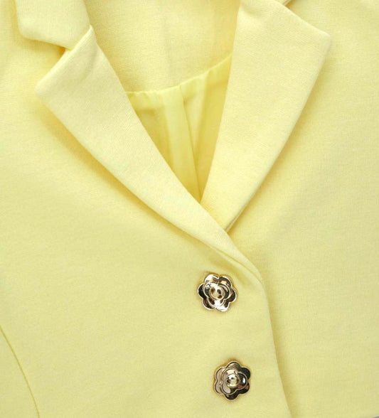 Λεπτομέρεια από τα διακοσμητικά κουμπιά λουλούδια και την ύφανση της παιδικής ζακέτας.