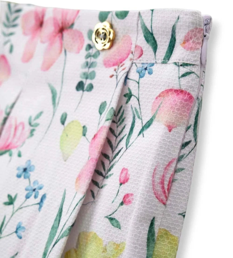 Λεπτομέρεια από τα διακοσμητικά κουμπιά και τις πιέτες στη φλοράλ κοριτσίστικη βερμούδα.
