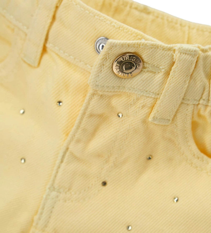 Λεπτομέρεια από τα στρας και τη μεταλλική ζώνη στην παιδική βαμβακερή βερμούδα.