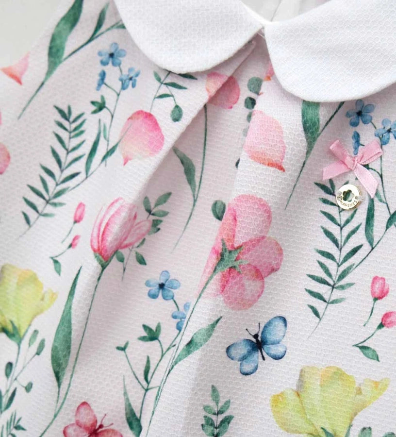 Λεπτομέρεια από τον στρογγυλό γιακά και το μεταλλικό charm στο φλοράλ κοριτσίστικο φόρεμα.