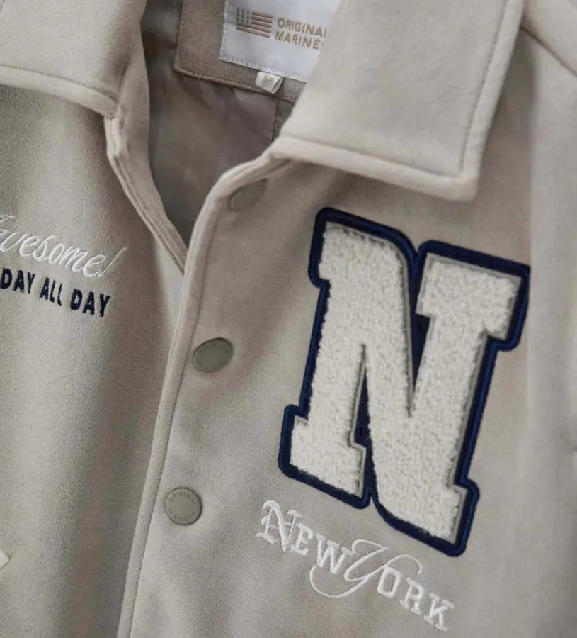 Λεπτομέρεια από το κεντημένο απλικέ και τα ριμπ τελειώματα στο εφηβικό μπουφάν.