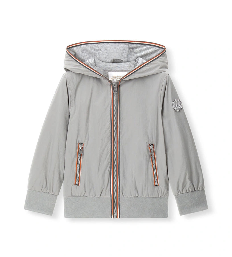 Παιδικό αντιανεμικό μπουφάν για αγόρι σε ανοιχτό γκρι χρώμα με κουκούλα και φερμουάρ.
