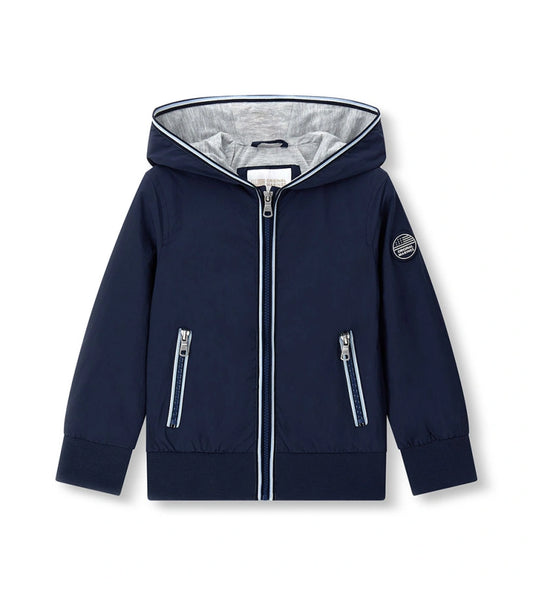 Παιδικό αντιανεμικό μπουφάν για αγόρι σε σκούρο μπλε χρώμα με κουκούλα και φερμουάρ.