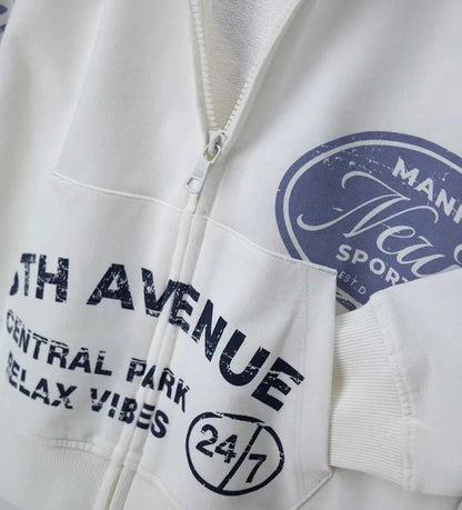 Λευκή παιδική ζακέτα Original Marines με κουκούλα, φερμουάρ και μπλε στάμπες New York.