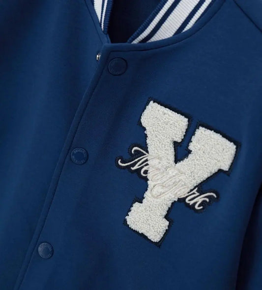 Λεπτομέρεια από το τεχνικό ύφασμα interlock και τα κουμπιά σούστες στο παιδικό τζάκετ.