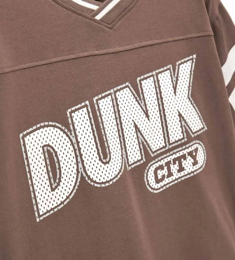 Λεπτομέρεια από τον ριμπ γιακά και το τύπωμα στο μπροστινό μέρος της μπλούζας.