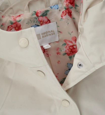 Λεπτομέρεια από την εμπριμέ φόρμα και τα logo snap buttons του κοριτσίστικου μπουφάν.