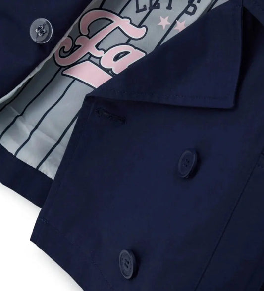 Λεπτομέρεια από την εμπριμέ φόδρα και τα κουμπιά της παιδικής καμπαρντίνας.