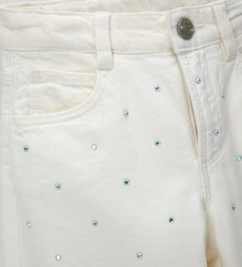 Κοντινό πλάνο στα στρας και την υφή του garment-dyed υφάσματος στο παντελόνι Original Marines.