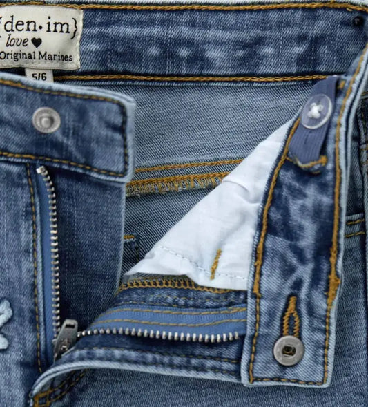 Κοντινό πλάνο στο ρυθμιζόμενο λάστιχο της μέσης και την ποιότητα του ελαστικού denim.