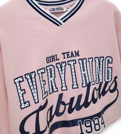 Λεπτομέρεια από τη V λαιμόκοψη και τις ριμπ μανσέτες στο κοριτσίστικο φούτερ.