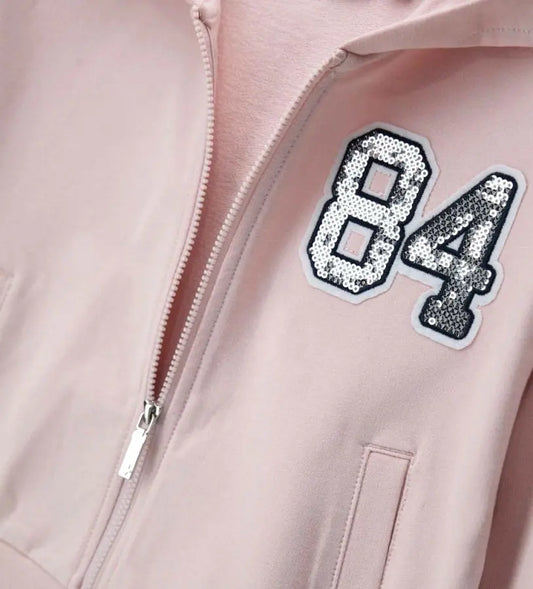 Λεπτομέρεια από το απλικέ με πούλιες και το φερμουάρ στην παιδική ζακέτα.