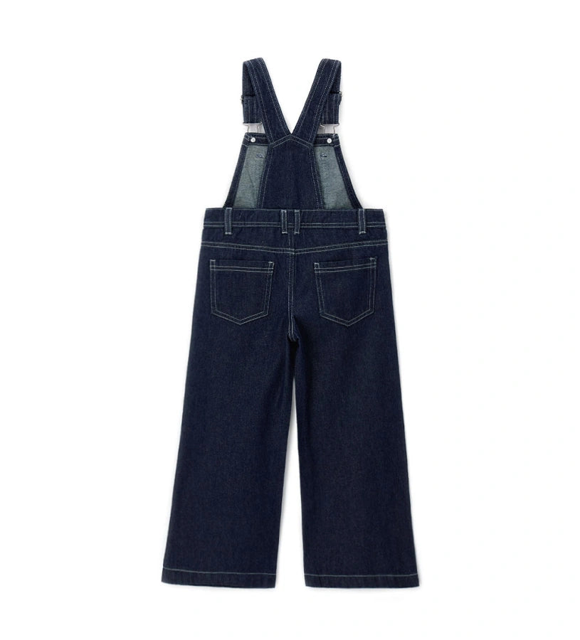 Πίσω όψη της τζιν σαλοπέτας που δείχνει τις τσέπες και την ασημί διακοσμητική ετικέτα.