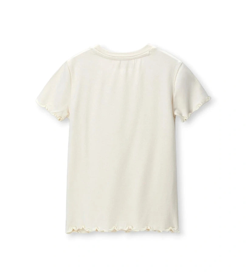 Το λευκό παιδικό T-shirt από το σετ 2 τεμαχίων με τη θηλυκή κυματιστή λεπτομέρεια.