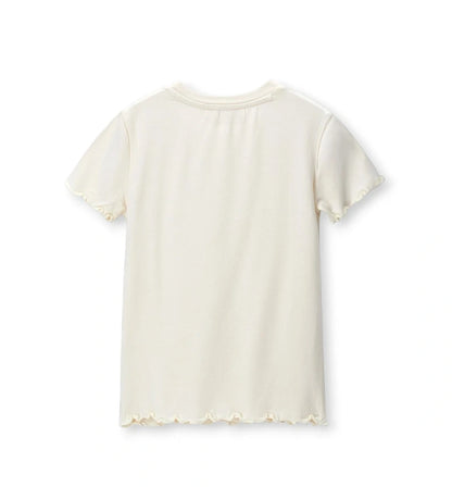 Το λευκό παιδικό T-shirt από το σετ 2 τεμαχίων με τη θηλυκή κυματιστή λεπτομέρεια.