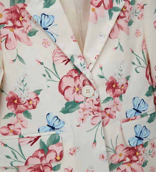 Λεπτομέρεια από το γυαλιστερό ύφασμα και τον γιακά με πέτο του κοριτσίστικου blazer.