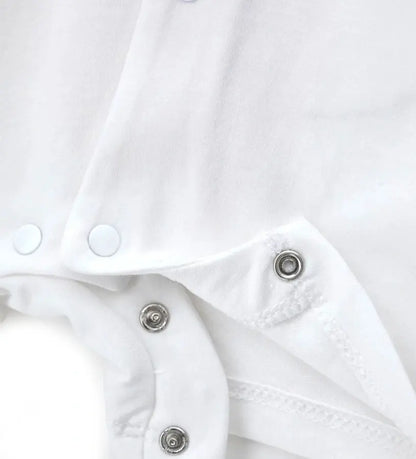 Κοντινό πλάνο στα κουμπιά-σούστες ανάμεσα στα πόδια και την υφασμάτινη ετικέτα στον ώμο.